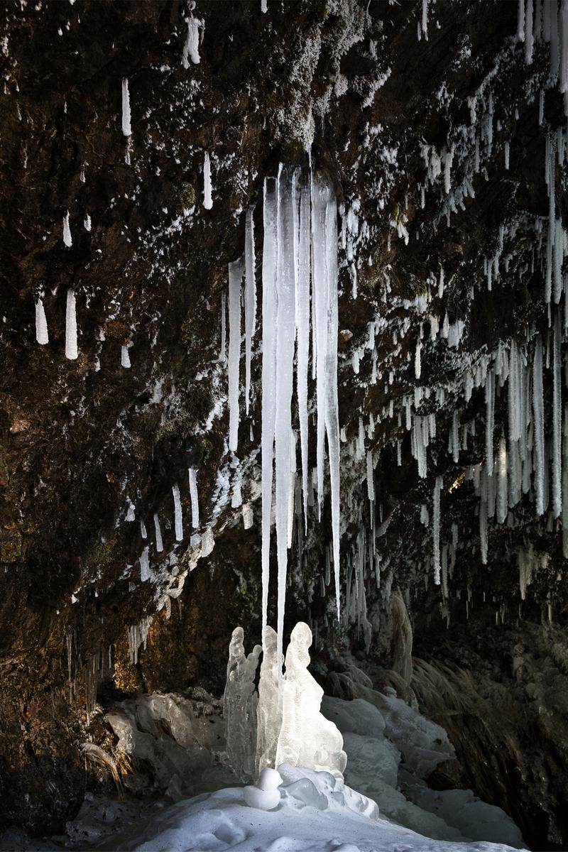 Large and small icicles (tsurara) hanging from a rock face and ice pillars rising from the ground