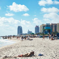 マイアミビーチの海岸線に立ち並ぶビル群と行き交う人々の写真