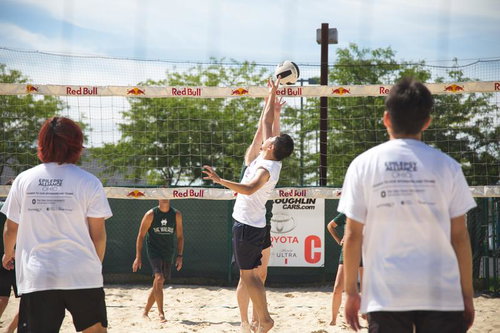 ビーチバレーの試合でボールをトスするプレイヤー