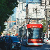 トロント市街地を走る赤と白の路面電車の写真