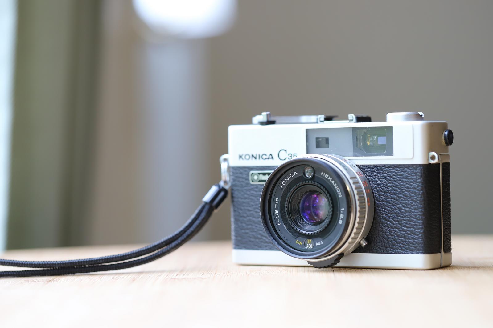 白黒のKONICA C35フィルムカメラにストラップを装着した状態
