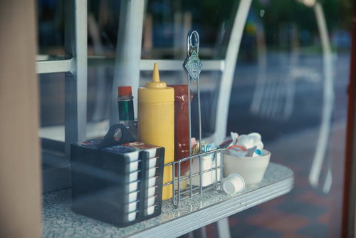 窓越しに並ぶケチャップとマスタードのボトル