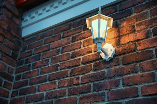 レンガ壁を照らす夜間の街灯 - 暖色光の建築照明