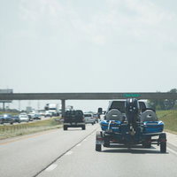 高速道路でバスボートを牽引する釣り人の車の写真