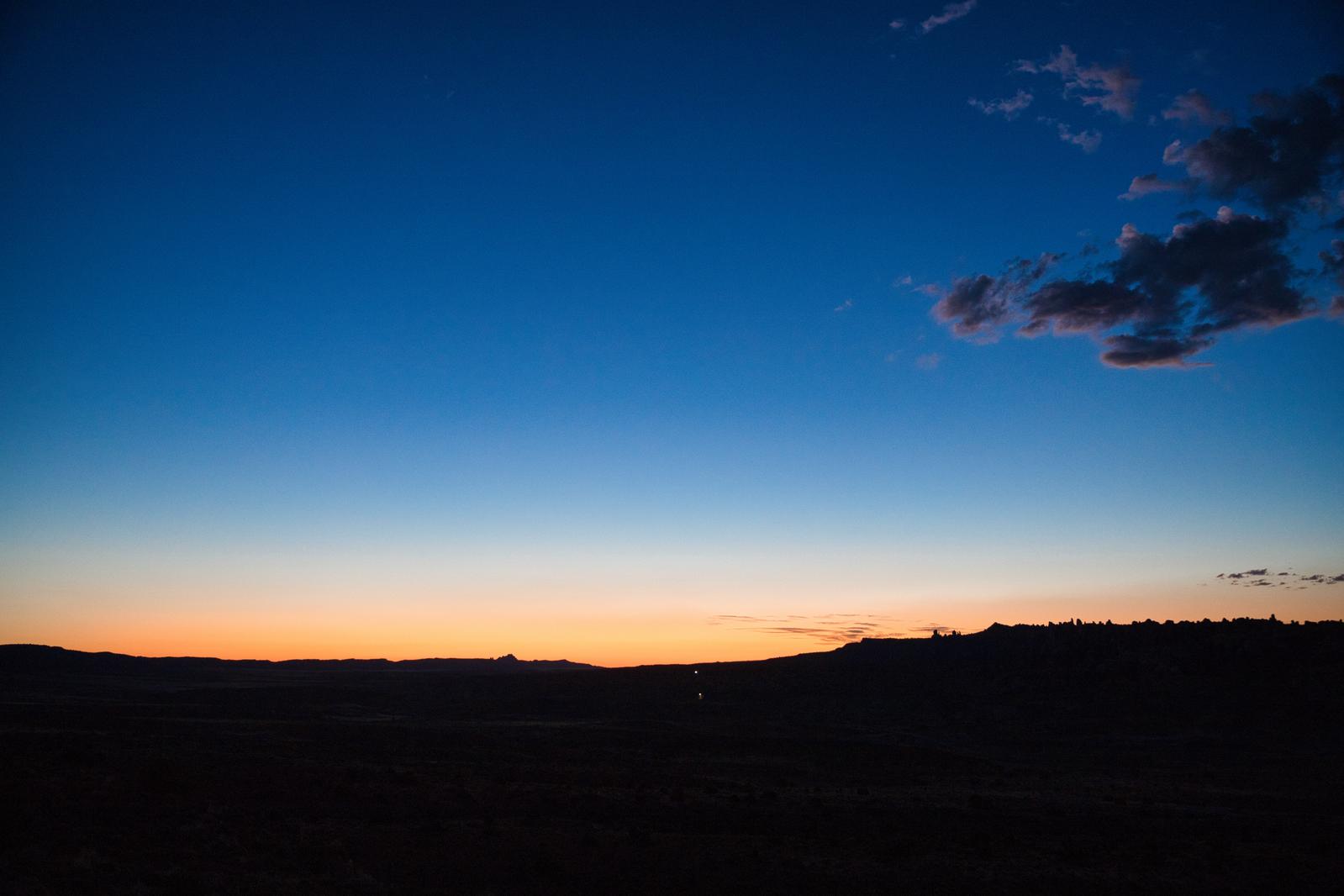 オレンジ色の夕焼け空から青い夜空へグラデーションする地平線の風景