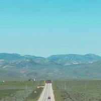 アメリカの広大な平原に続く一本道、地平線まで真っすぐ伸びる国道の写真