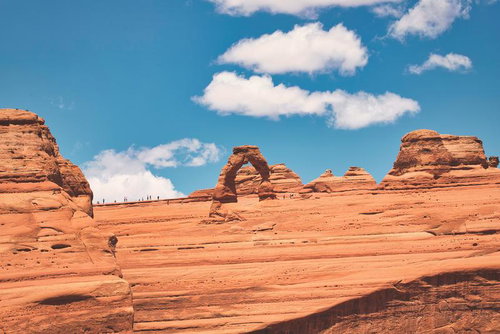 アーチズ国立公園のデリケートアーチ、赤い岩山と青空に佇む遠景