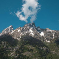 グランドティトン国立公園のティトン山、残雪と針葉樹林が連なる雄大な山容の写真
