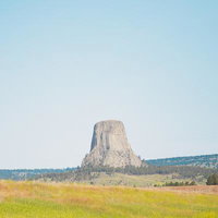デビルズタワーを望むデヴィルス・タワー国定公園の広大な草原の写真