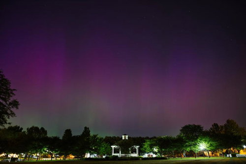 夜空に広がる紫色のオーロラと公園のガゼボ