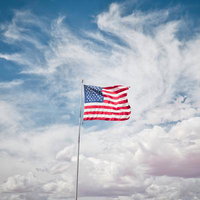 青空に翻るアメリカの星条旗が風になびく愛国心を表現する国旗の写真