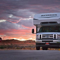 ブライスキャニオンの夕焼け空を背景に停車するキャンピングカーの写真