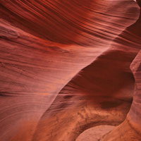 アンテロープキャニオンの内部に広がる赤茶色の岩壁と浸食模様の写真