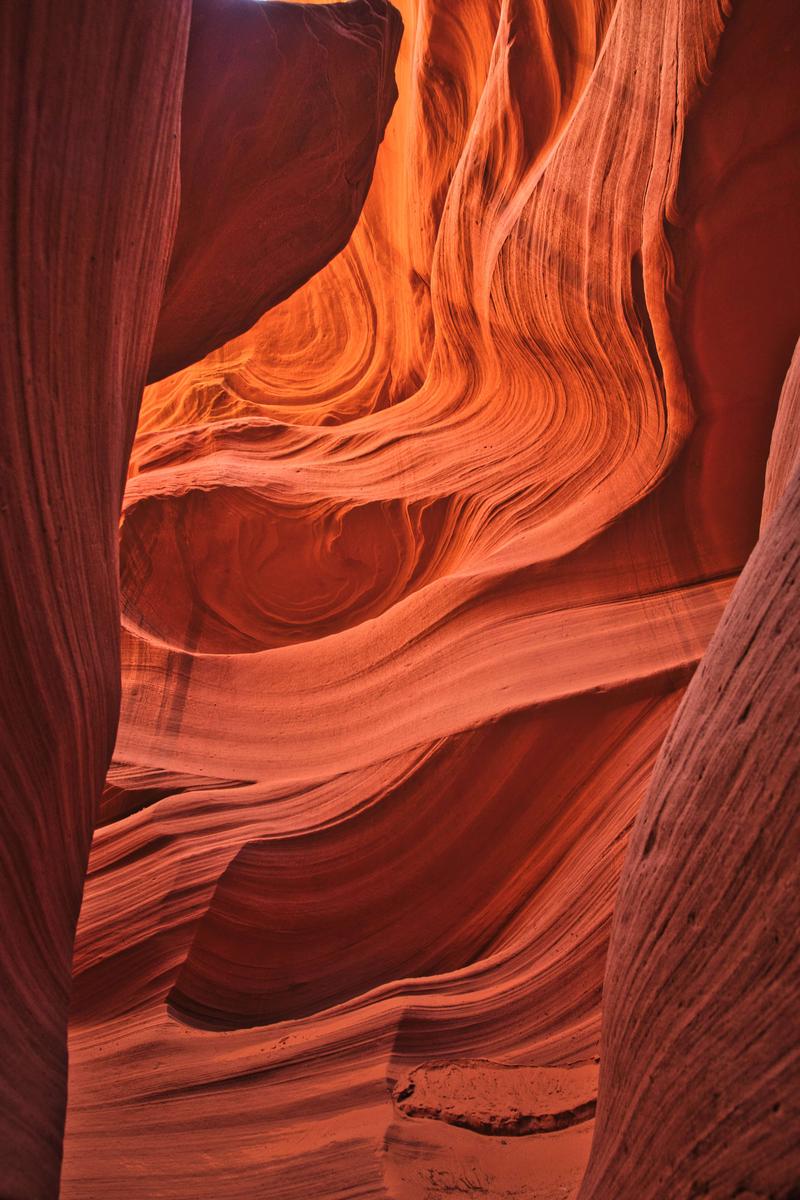 光が差し込むアンテロープキャニオンの曲線的な砂岩層の写真