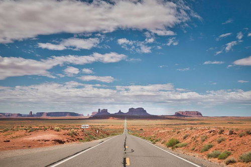 モニュメントバレーへ続く一直線の道路と壮大な砂漠風景