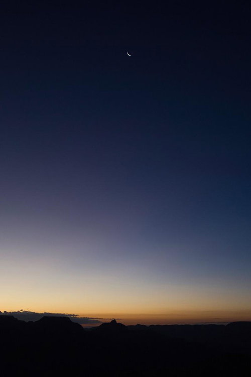 薄暗い空に浮かぶ三日月とグランドキャニオンの地平線