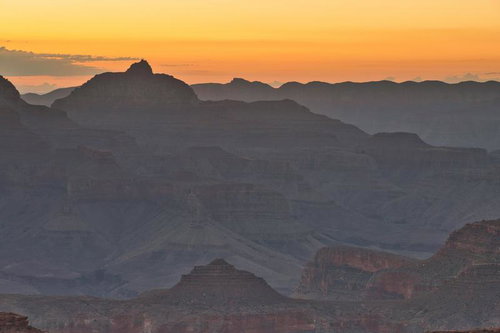 夕暮れのグランドキャニオンとシルエットの山々が連なる大峡谷