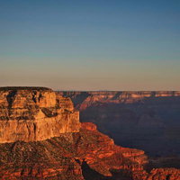 朝焼けに染まるグランドキャニオンの雄大な岩肌と峡谷の写真