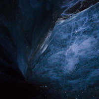 洞窟内の暗く青い氷壁の奥行きある自然の造形の写真