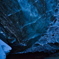氷河洞窟内部の青白い氷壁と模様、層状に堆積した氷の構造の写真