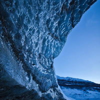 空に向かってそびえ立つ氷河の氷壁と複雑な凹凸の模様の写真