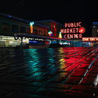 PUBLIC MARKET CENTERのネオン看板が夜の路面に映り込む風景の写真