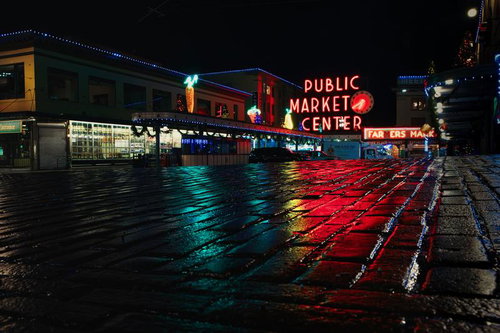 PUBLIC MARKET CENTERのネオン看板が夜の路面に映り込む風景