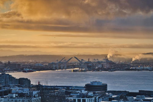 夕焼けに染まるシアトルの港湾風景と大型クレーン群