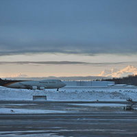 冬の空港滑走路で雪に覆われた地に静かに佇むUPS貨物機の写真