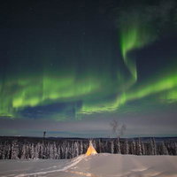 ティーピーと北極圏のオーロラが織りなす雪原の夜の写真