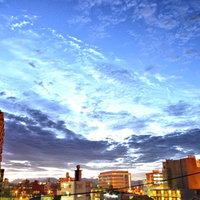 紫色のグラデーションに染まる日が沈む前の街並みの写真