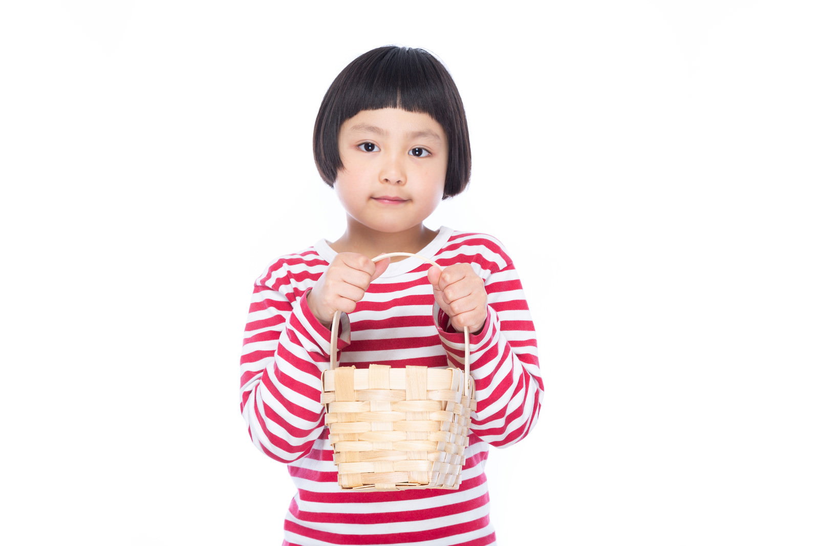 籐のバスケットを両手で持つ前髪パッツンの女の子［モデル：ゆうき］