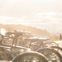 夕焼けに染まる河川敷に駐輪する自転車と夕景の写真