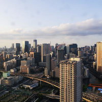 夕日に染まる東京の高層ビル群と湾岸スカイラインの写真