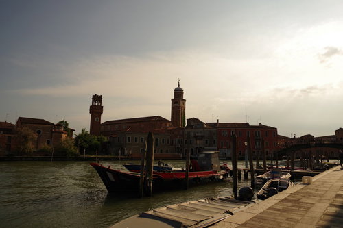 夕暮れ時のベネチア、運河沿いの船着き場と歴史的建造物