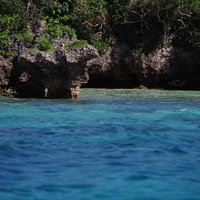 石垣島の透明度の高い青い海と切り立った岩場の写真
