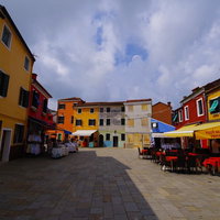 ブラーノ島のカラフルな建物が囲む石畳の広場（イタリア）の写真