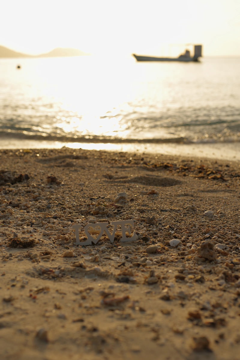 夕焼けの砂浜に置かれたLOVEの文字オブジェクト