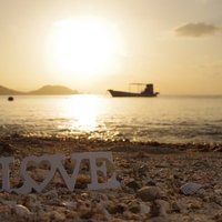 夕暮れの砂浜に置いたLOVEの文字オブジェクトの写真