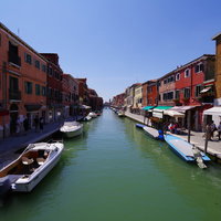 ブラーノ島の水路と船着き場、カラフルな建物が映るイタリアの風景の写真