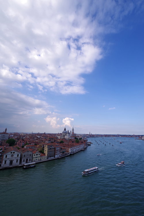 船上から見下ろすベネツィアの運河と水上バスが行き交う景観（イタリア）