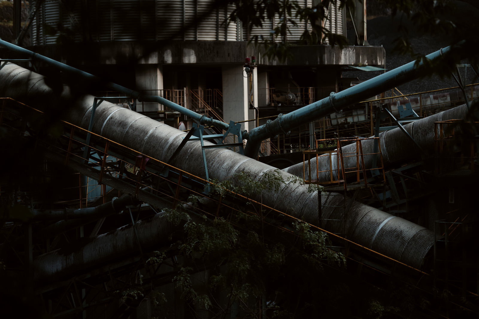 山の奥地にある採石場の工業設備が薄暗い環境に配置されている様子