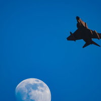 夕日を浴びるF-4と輝きを増す月の写真