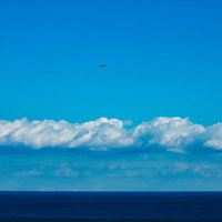 真っ青な海と空との間に伸びる水平線の写真