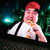 赤い帽子をかぶってポテチを食べながらビデオ通話する男性の写真