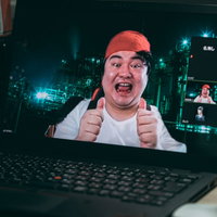 潜入先からビデオ通信でグッジョブをする男性の写真