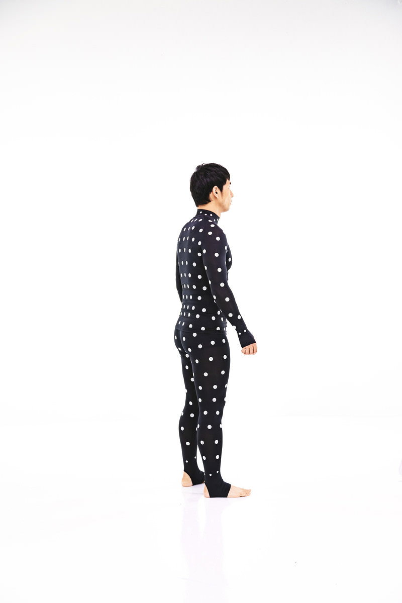 黒い水玉模様のZOZOSUITを着用して横向きに立つ男性［モデル：大川竜弥］