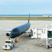ボーディングブリッジが外されプッシュバックされる飛行機の写真