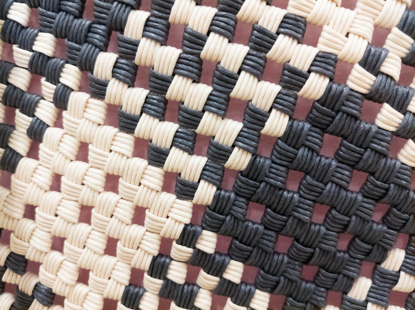 Texture of the weave pattern on a handmade basket, created with different colored woven threads
