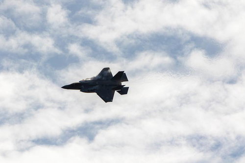 曇り空を背景に飛行する航空自衛隊のF-35ライトニング戦闘機